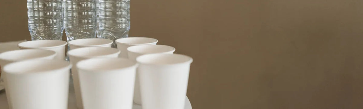Bottled water and paper cups on a breakroom table